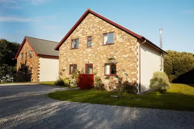a brick house with a driveway in front of it at KingFisher Hot Tub & log Burner house on Premium lakeside with Resort Facilities in Saint Columb Major