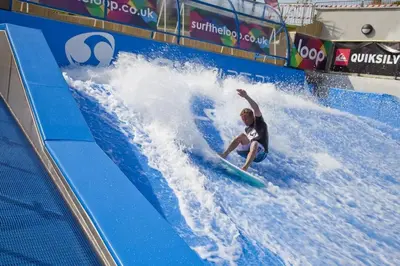 a man riding a wave on a surfboard in a wave tunnel at KingFisher Hot Tub & log Burner house on Premium lakeside with Resort Facilities in Saint Columb Major