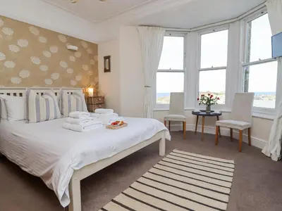 a bedroom with a white bed with towels on it at Whistler in St Ives
