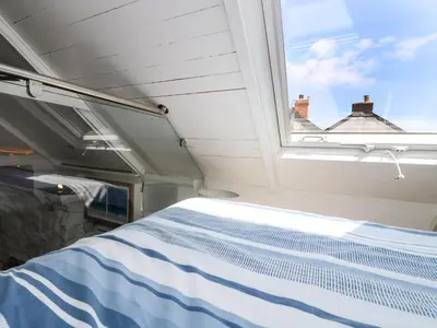 a bed in a room with a window at The Old Stable in Helston