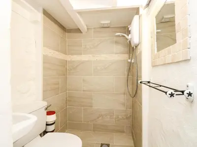 a bathroom with a toilet and a shower at The Old Stable in Helston