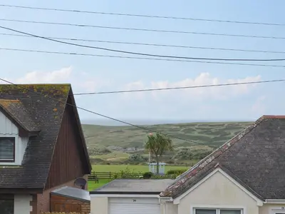 a group of houses with hills in the background at Poppy Cottage in Crantock