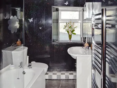 a bathroom with a toilet and a sink and a window at Trecarne Cottage in Saint Cleer