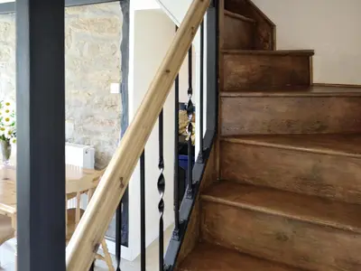 a wooden staircase in a house with a table at Trecarne Cottage in Saint Cleer
