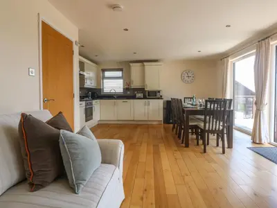 a living room with a couch and a table with chairs at Redwood, Retallack in Newquay