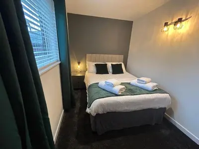 a small bedroom with a bed with towels on it at Redwood, Retallack in Newquay
