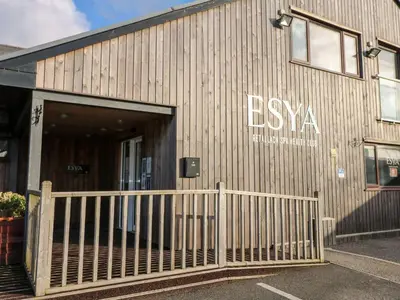 a building with a wooden fence in front of it at Redwood, Retallack in Newquay