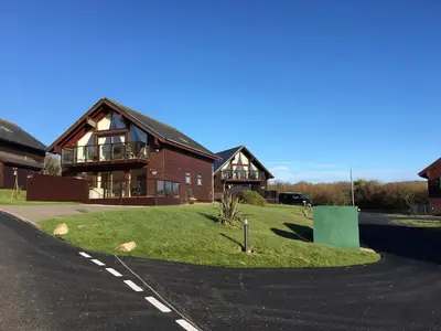 a house with a green lawn in front of it at Redwood, Retallack in Newquay