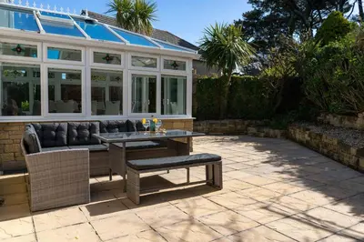 a patio with a couch and a table in front of a house at Sea La Vie in Carbis Bay