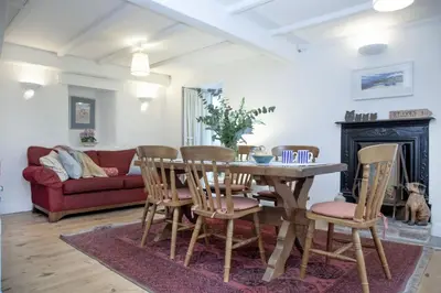 a living room with a wooden table and chairs at Laity Vean Farmhouse and Hideaway in Carbis Bay
