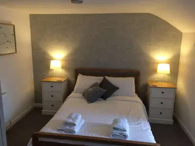 a bedroom with a large bed with two night stands at Portreath Arms in Portreath