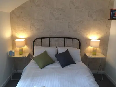 a bedroom with a bed with two lamps on both sides at Portreath Arms in Portreath