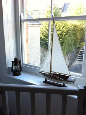 a small sail boat sitting on a window sill at Harbour Retreat Padstow - Entire Apartment in the beautiful old town of Padstow Harbour in Padstow