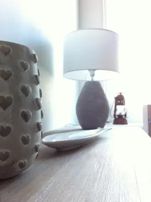 a cat sitting on a chair next to a lamp at Harbour Retreat Padstow - Entire Apartment in the beautiful old town of Padstow Harbour in Padstow