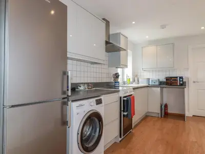 a kitchen with a washer and dryer at Lowenek in Bodmin