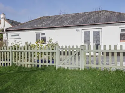 a fence in front of a white house at Lowenek in Bodmin