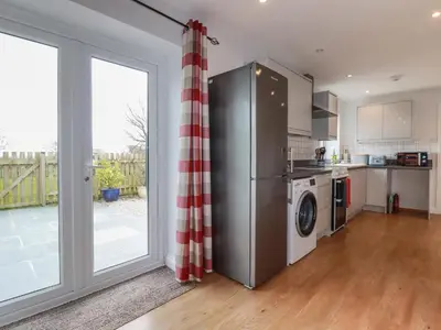 a kitchen with a washer and dryer next to a window at Lowenek in Bodmin