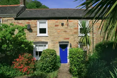 a brick house with a blue door at Gargoyle Cottage in St. Agnes