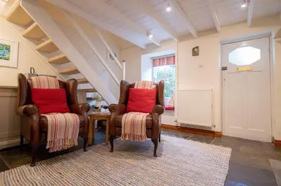 a living room with two chairs and a table at Gargoyle Cottage in St. Agnes