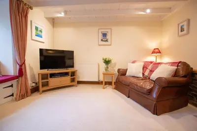 a living room with a couch and a flat screen tv at Gargoyle Cottage in St. Agnes
