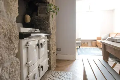a kitchen with a stove and a stone wall at No3 Gweek in Gweek