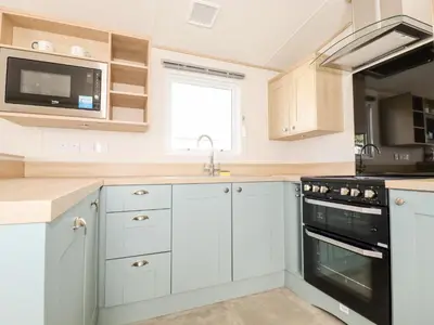 a kitchen with white cabinets and a sink at 109 Bude in Newquay
