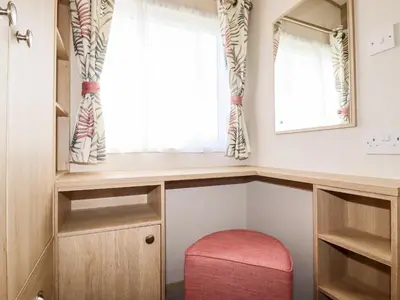 a small room with a window and a red stool at 109 Bude in Newquay