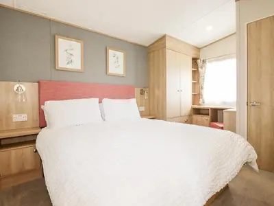 a bedroom with a large white bed with a red headboard at 109 Bude in Newquay