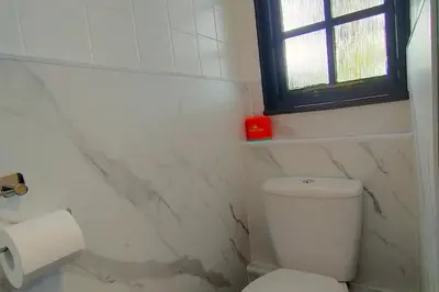a white bathroom with a toilet and a window at Tudor Cottage Hayle - a Family & Dog Favourite in Hayle