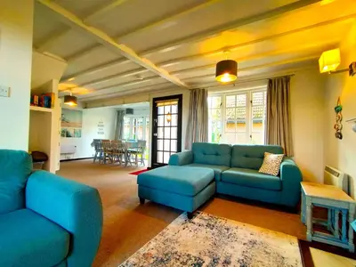 a living room with blue couches and a table at Tudor Cottage Hayle - a Family & Dog Favourite in Hayle