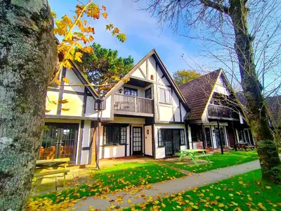 a large white house with a balcony on a yard at Tudor Cottage Hayle - a Family & Dog Favourite in Hayle