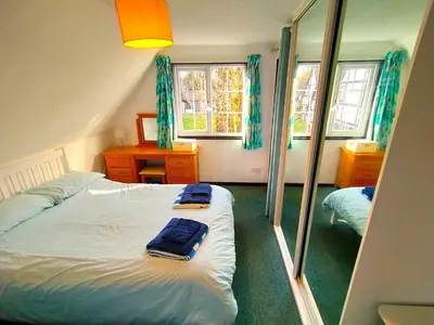 a bedroom with a bed and a mirror at Tudor Cottage Hayle - a Family & Dog Favourite in Hayle