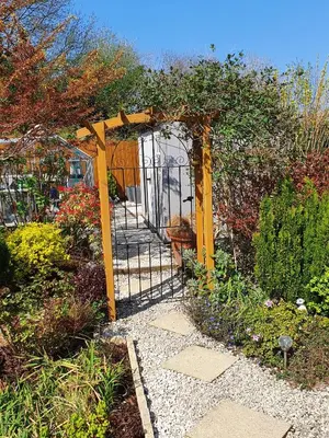 a gate in the middle of a garden at Eden's Rest Bed and Breakfast in St Austell