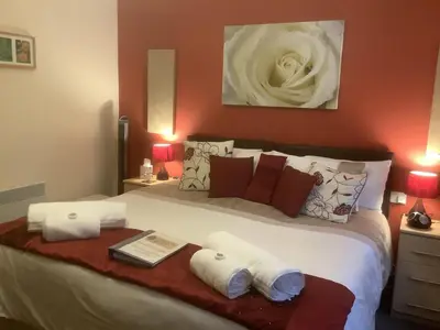 a bedroom with a large bed with towels on it at Eden's Rest Bed and Breakfast in St Austell