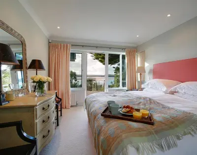 a bedroom with a bed with a tray of food on it at Camel Point in Wadebridge