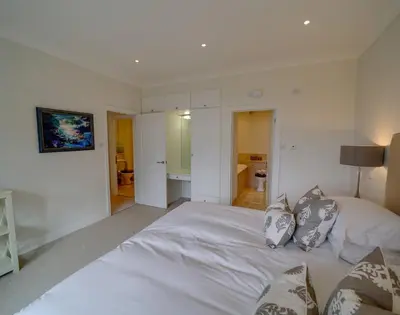 a bedroom with a large white bed with two pillows at Camel Point in Wadebridge