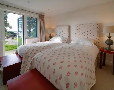 a bedroom with a large bed and a large window at Camel Point in Wadebridge
