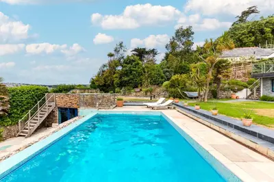 a swimming pool with blue water in a yard at Camel Point in Wadebridge