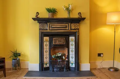 a fireplace in a room with yellow walls at Clevedon House - Newquay - Beaches - Parking in Newquay