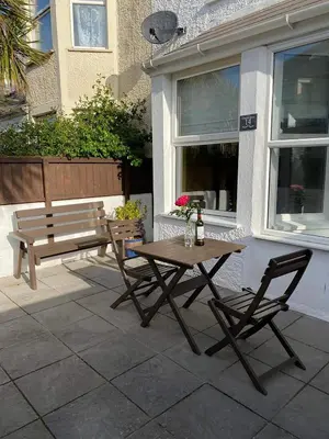 a picnic table and a bench in front of a building at Clevedon House - Newquay - Beaches - Parking in Newquay