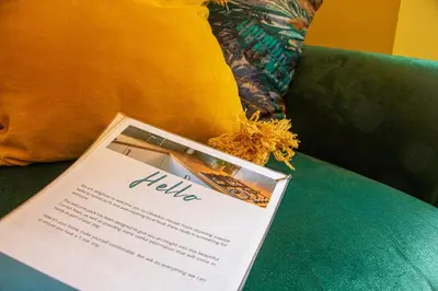a table with a book on top of a couch at Clevedon House - Newquay - Beaches - Parking in Newquay