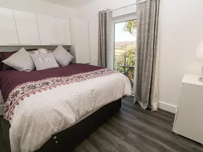a bedroom with a large bed and a window at Perran Pearl A in Perranporth