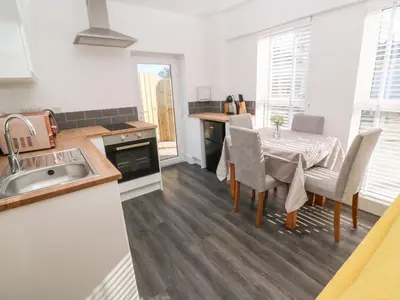 a kitchen with a table and chairs and a sink at Perran Pearl A in Perranporth