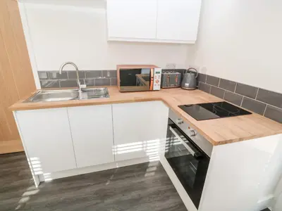 a kitchen with white cabinets and a sink at Perran Pearl A in Perranporth