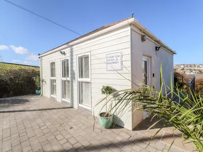 a small white building with a potted plant next to it at Perran Pearl A in Perranporth