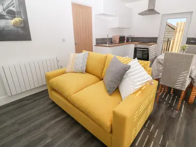 a yellow couch with pillows in a living room at Perran Pearl A in Perranporth