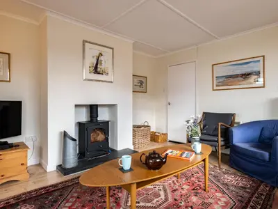 a living room with a fireplace and a blue couch at Croft Elms in Wadebridge