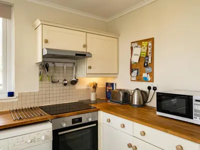 a kitchen with a stove and a microwave at Croft Elms in Wadebridge