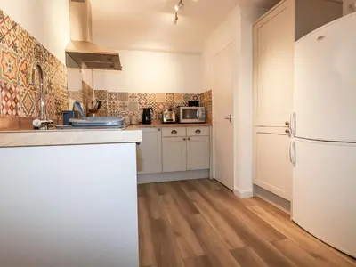 a kitchen with a white refrigerator and a wooden floor at EdyVean in St Austell