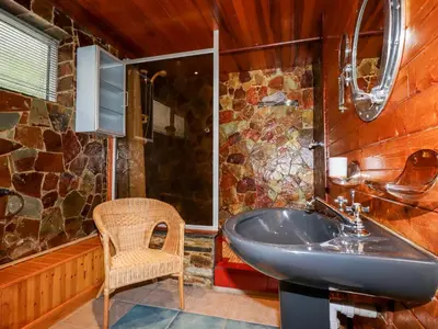 a bathroom with a sink and a chair at EdyVean in St Austell